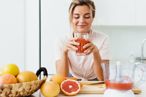 Жена пие прясно изцеден домашен грейпфрут