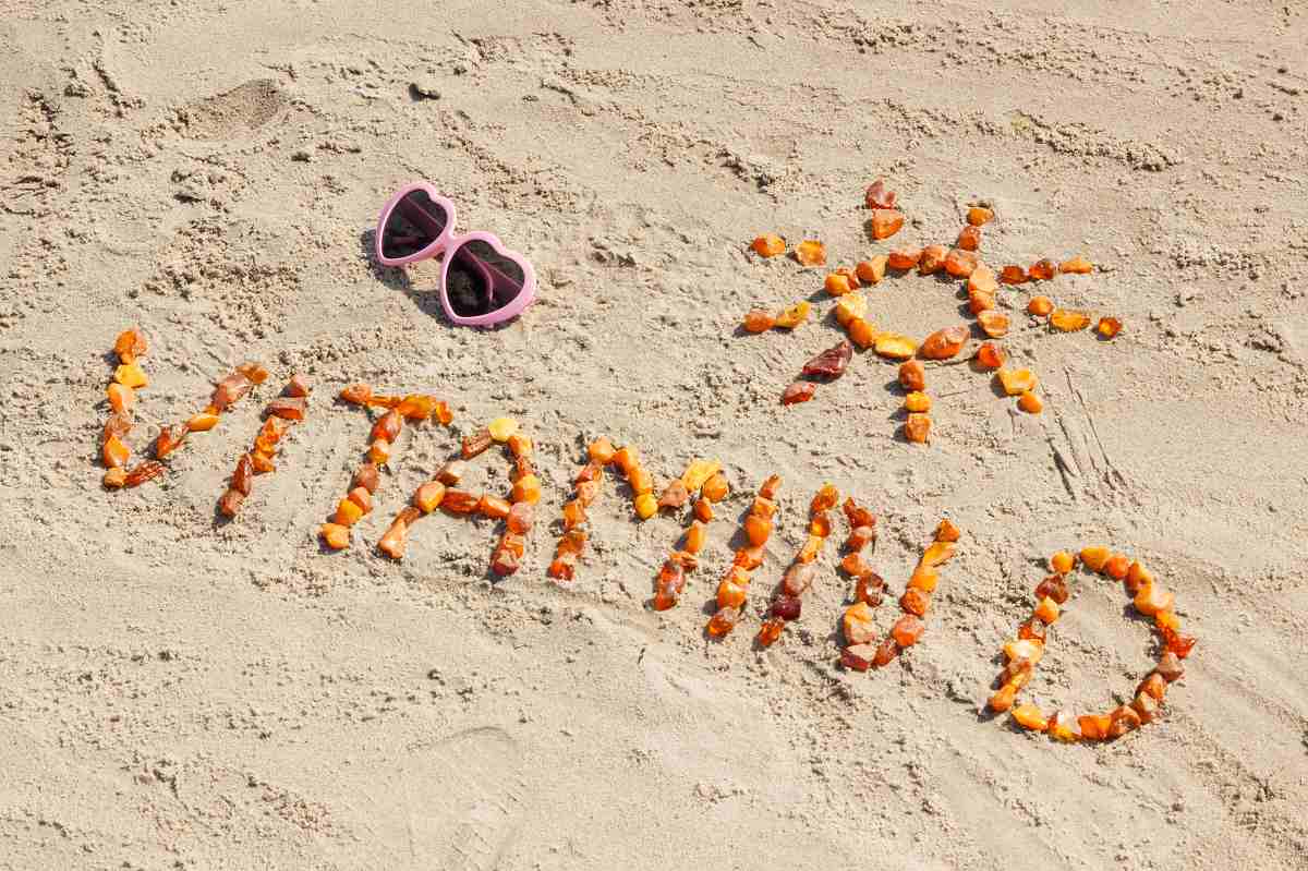 надпис витамин Д на пясък и слънчеви очила